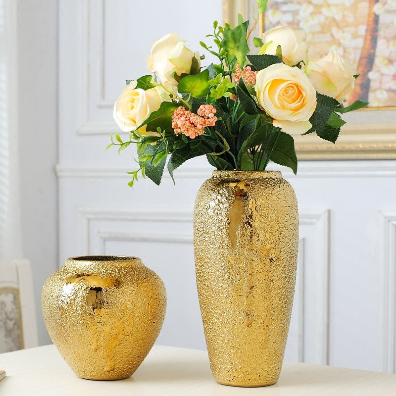 Gold tone ceramic vases with white and peach flowers in elegant home decor setting