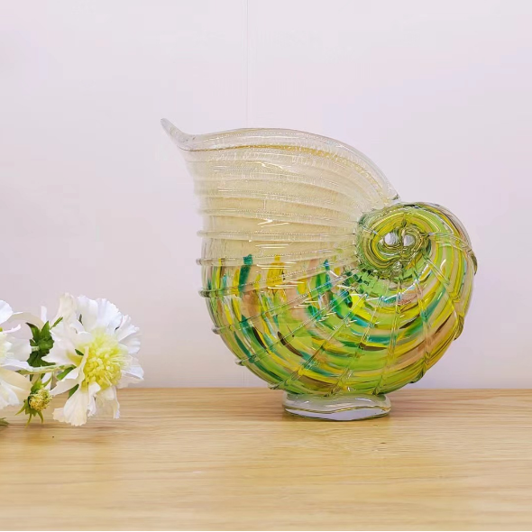 Green and amber nautilus shell art glass vase with ribbed texture