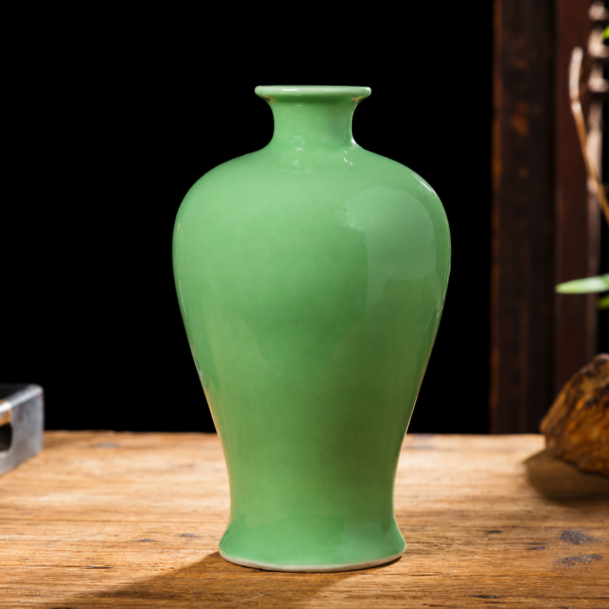 Green ceramic plum vase with curved body and narrow neck