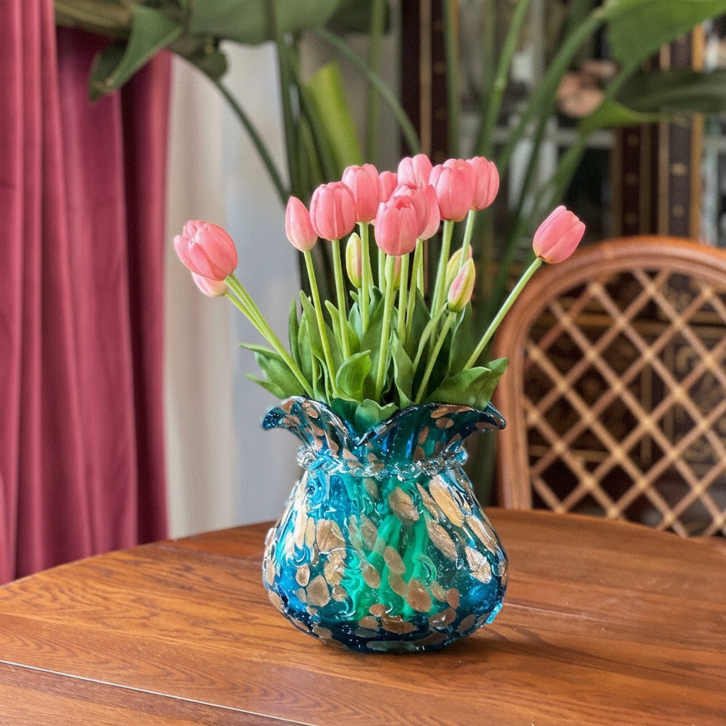 Blue sculptural art glass vase with tulips on wooden table