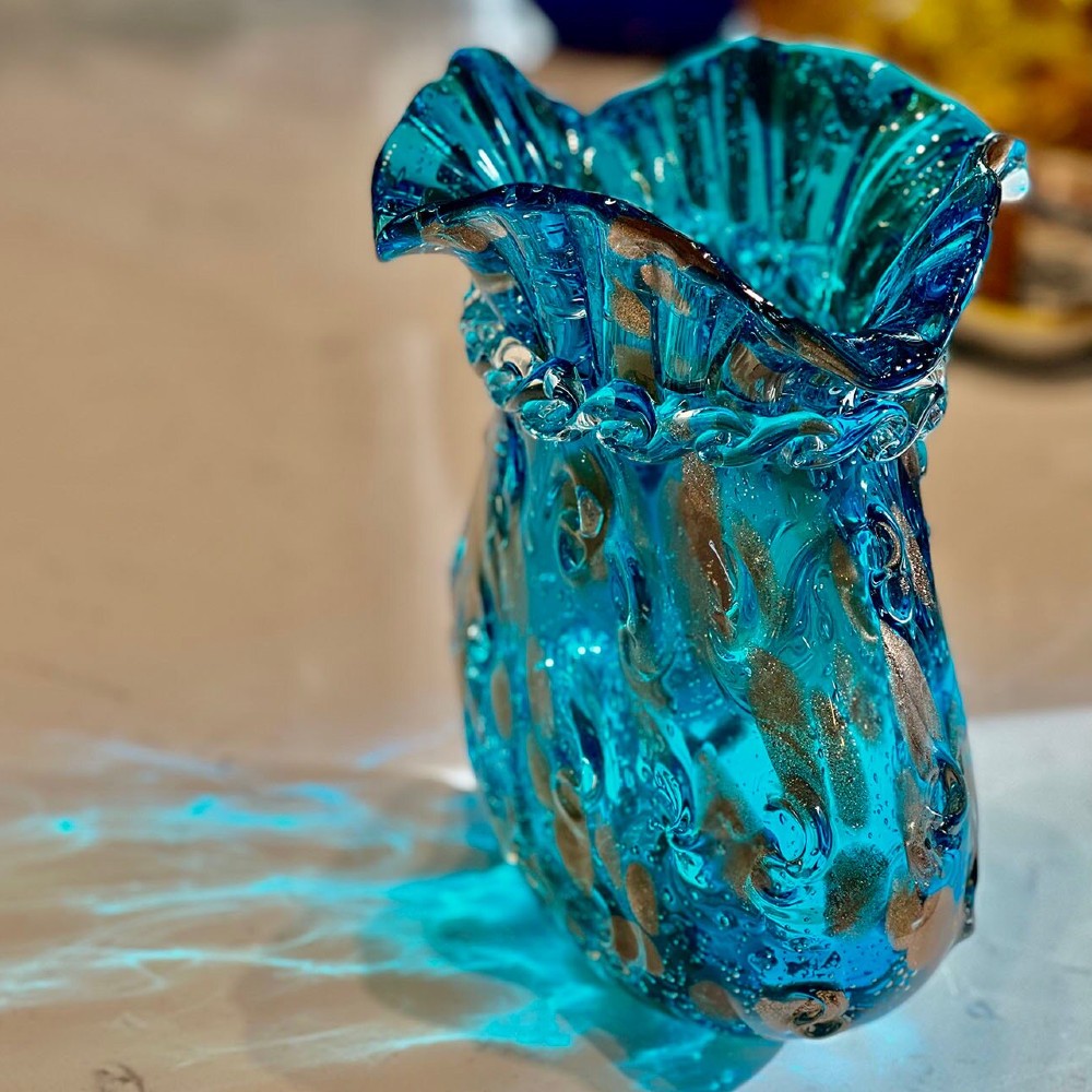 Tall angle view of hand blown blue art glass vase