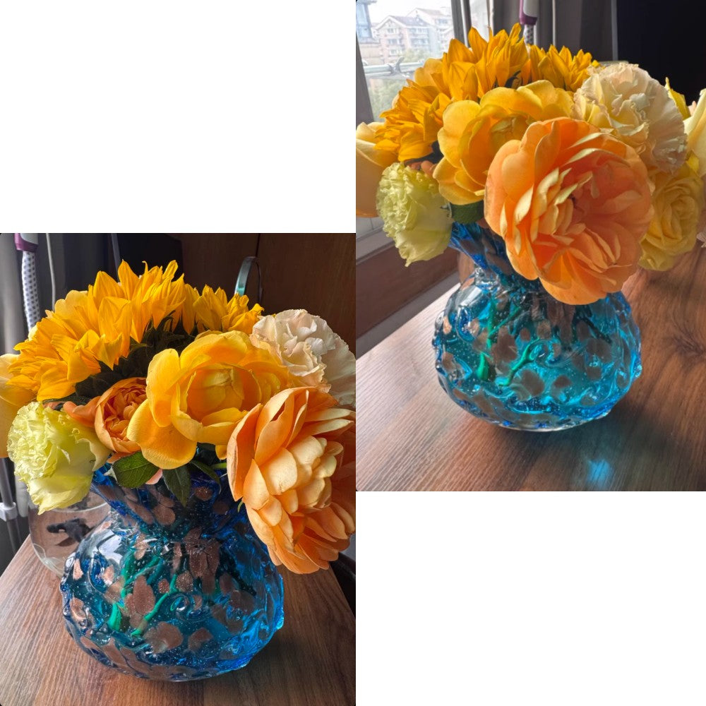 Blue art glass vase with orange flowers styled as centerpiece