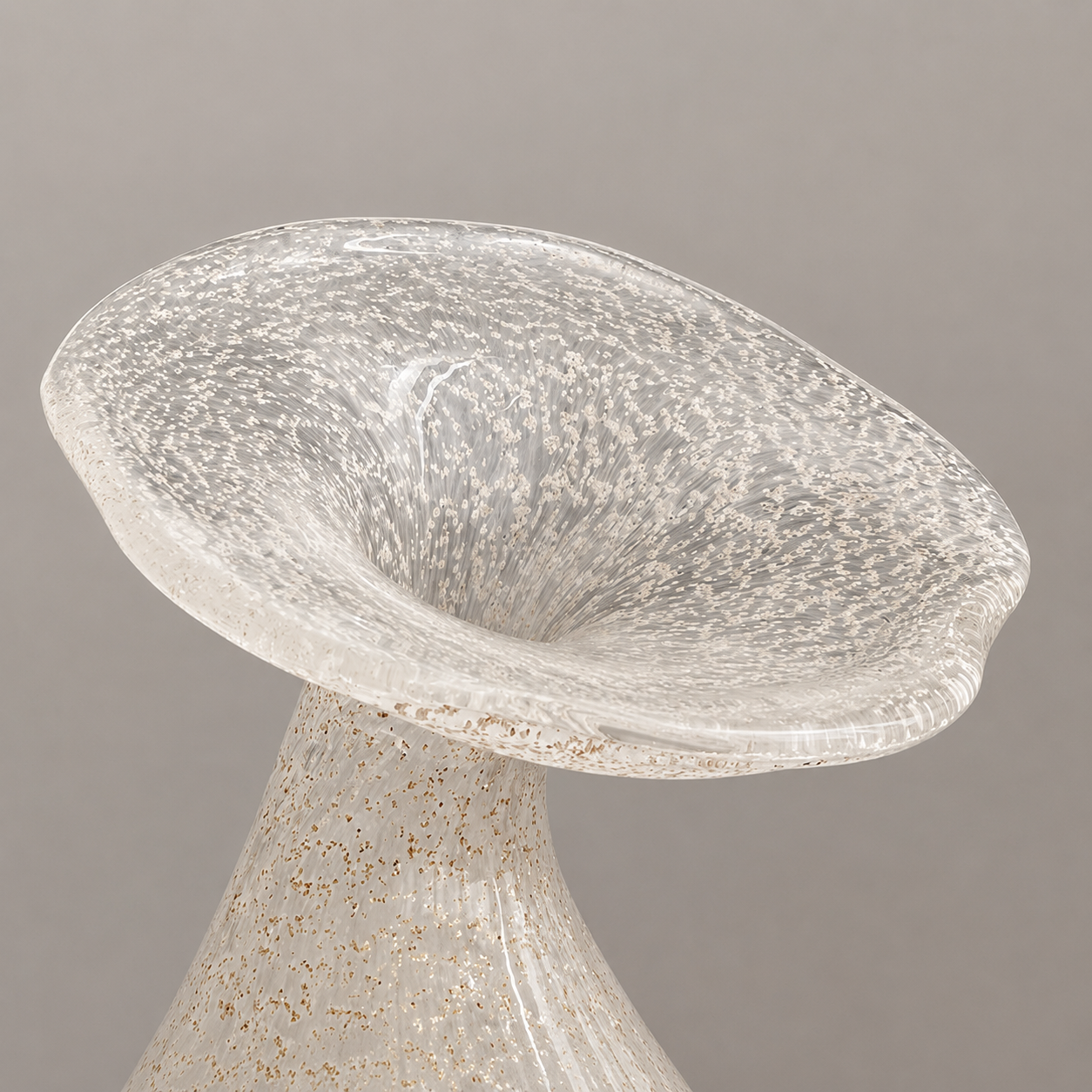 Close-up of hand-blown speckled glass vase with flared petal rim