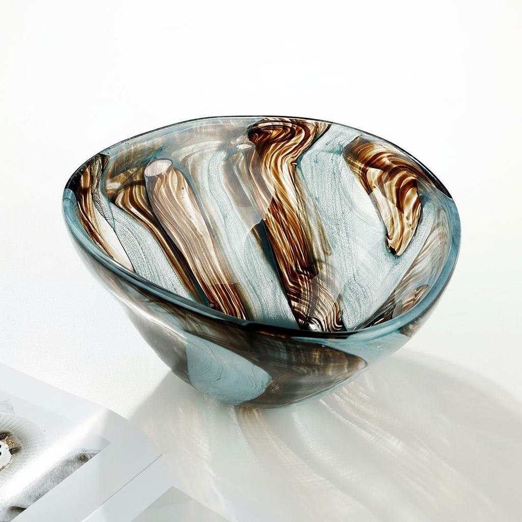 Hand-blown glass decorative bowl with free-form rim on a bright white surface