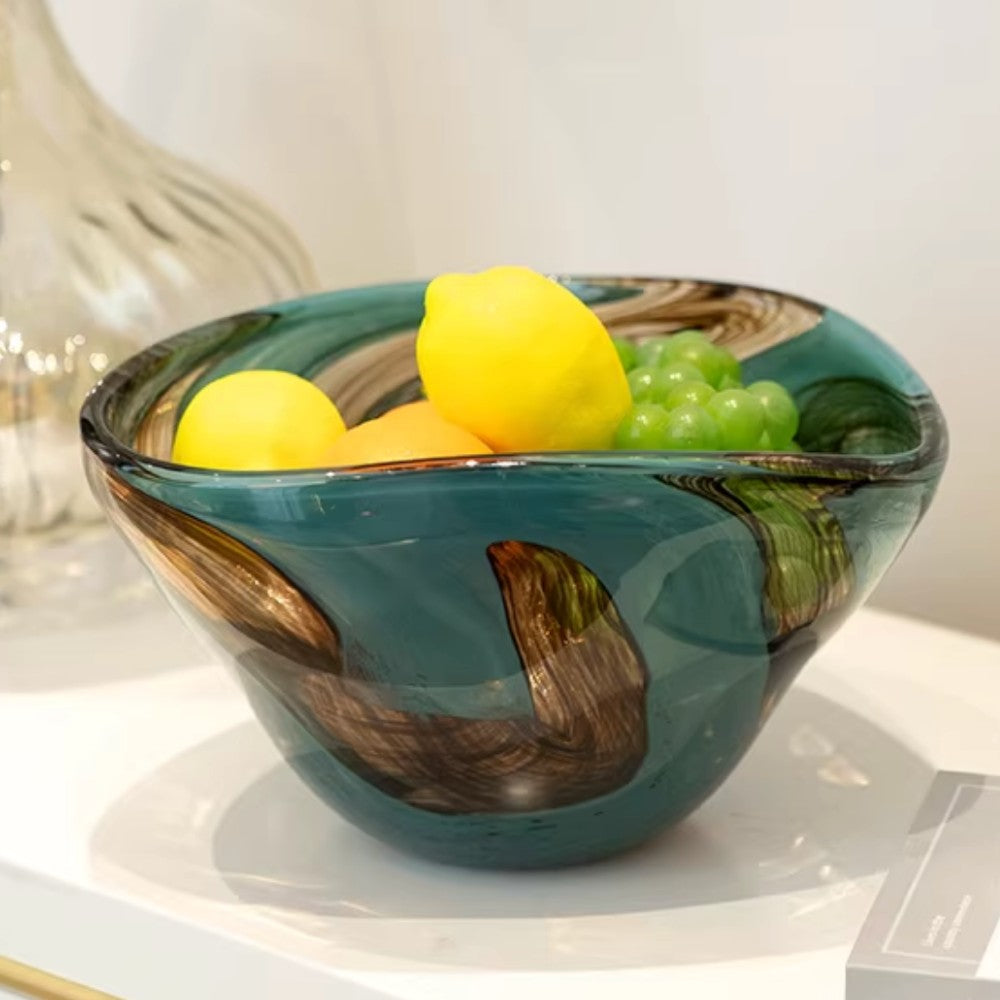 Decorative swirl glass bowl with lemons on a white tabletop in natural light