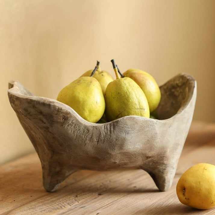 Hand carved wood footed centerpiece bowl styled with fresh pears on a rustic table