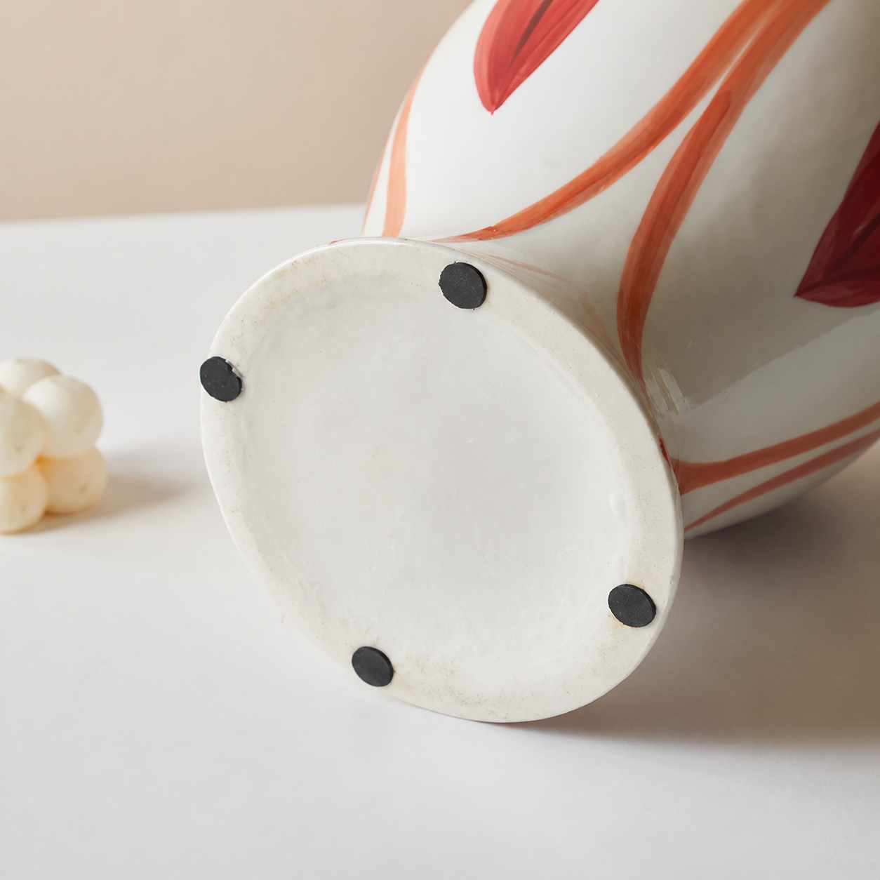 Bottom view of ceramic flower vase showing protective black pads and glazed base