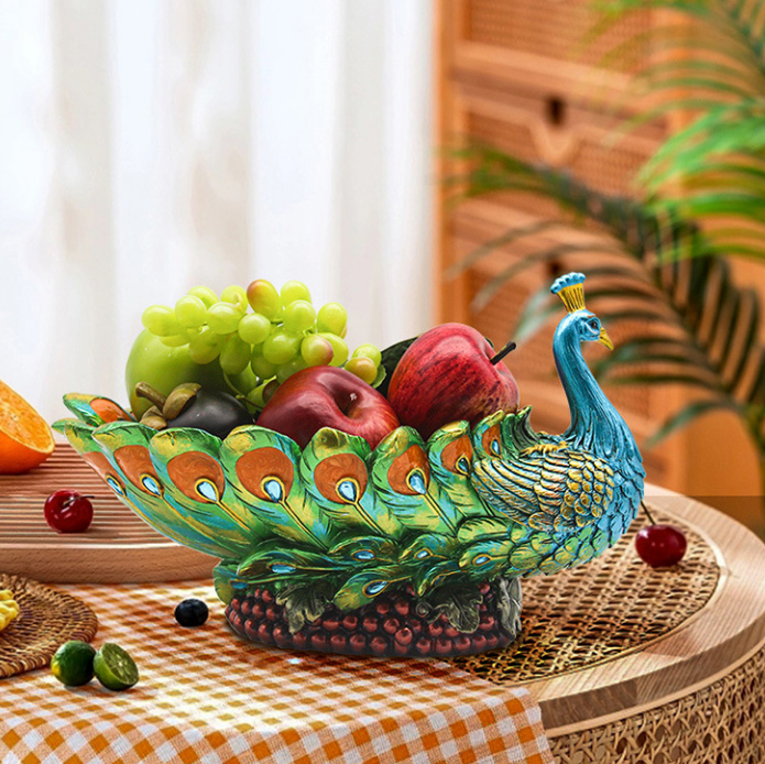 Hand-painted resin peacock fruit bowl centerpiece styled on a dining table with fresh fruit and elegant decor