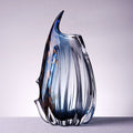 Medium handblown blue fluted art glass vase with curved organic rim and glossy finish