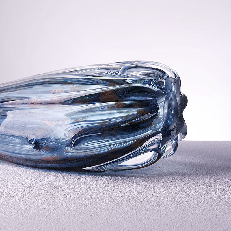 Blue and copper tone handblown fluted glass vase shown on its side to highlight flowing glass texture