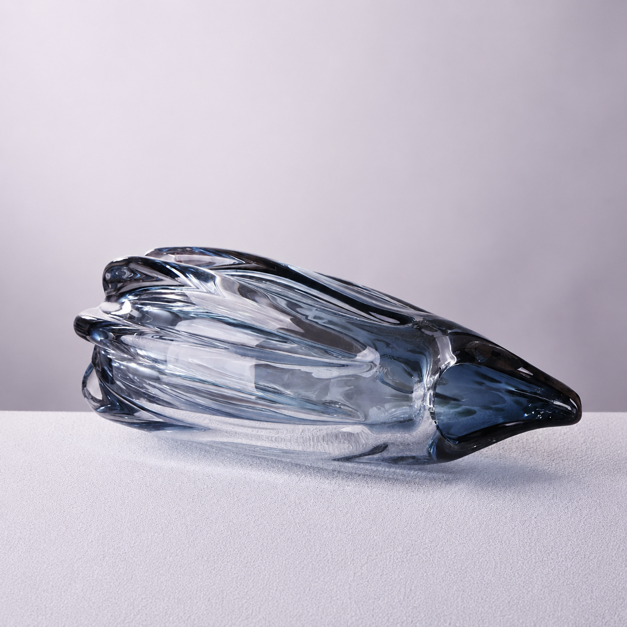 Square product photo of blue and copper tone fluted art glass vase lying on its side