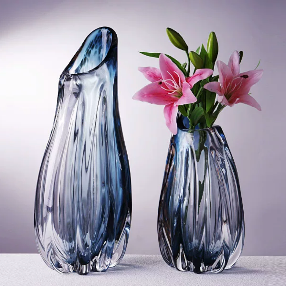 Tall handblown blue fluted glass vase styled with pink flowers for elegant interior decor