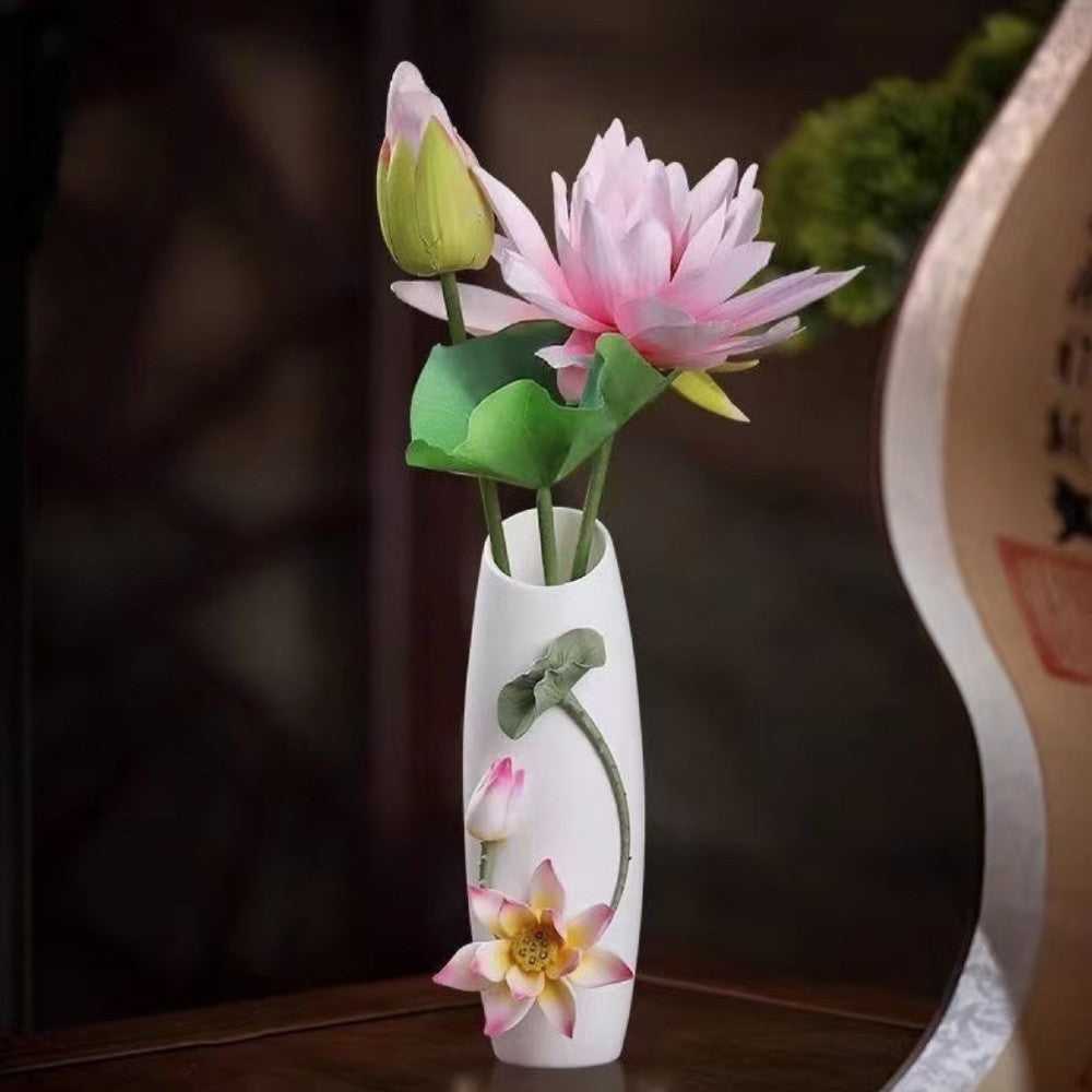 white ceramic floral relief vase with lotus flower arrangement styled in elegant interior