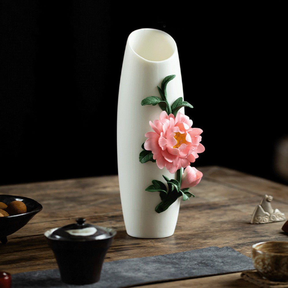 handcrafted white ceramic vase with peony floral relief detail on dark tabletop