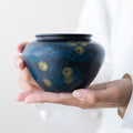 Midnight Blue handcrafted iron tea ritual bowl with gold starburst detailing held in hands
