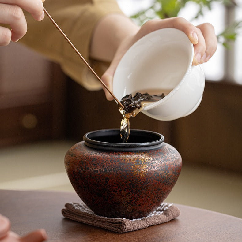 Burnished Maroon tea ritual bowl receiving water from a white teapot