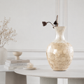 Handcrafted shell inlay ceramic vase styled on white table with dried botanical stems
