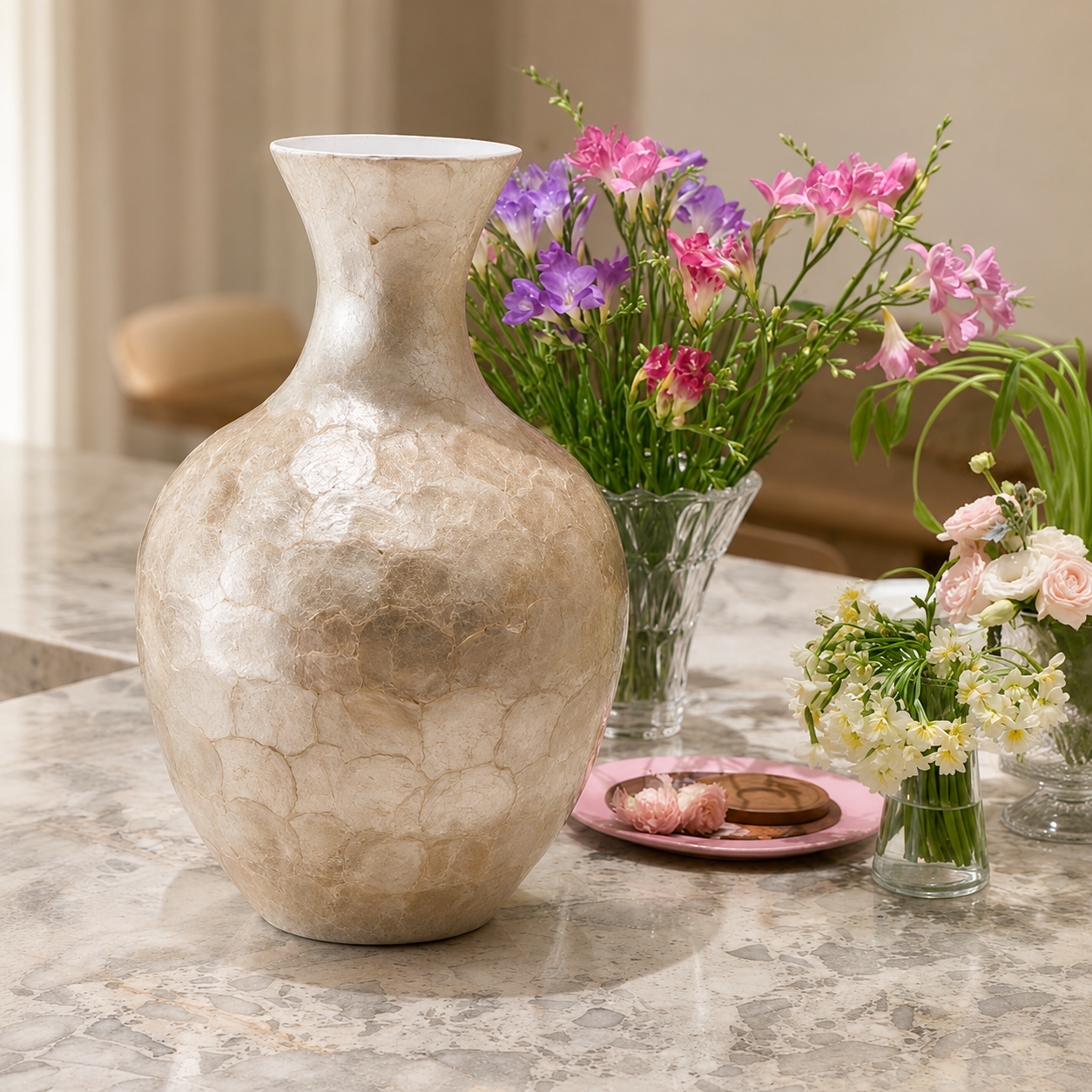 Large shell inlay ceramic vase displayed with colorful flowers on marble table
