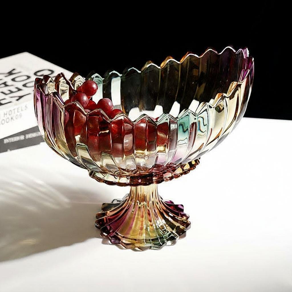 Iridescent scalloped glass centerpiece bowl with a pedestal base styled with red fruit on a tabletop