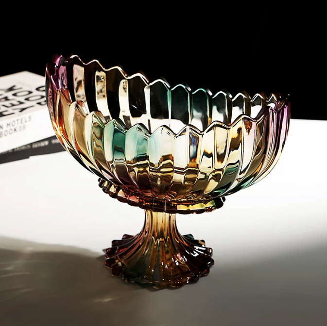 Pedestal iridescent glass centerpiece bowl with red fruit styled on a glossy black surface