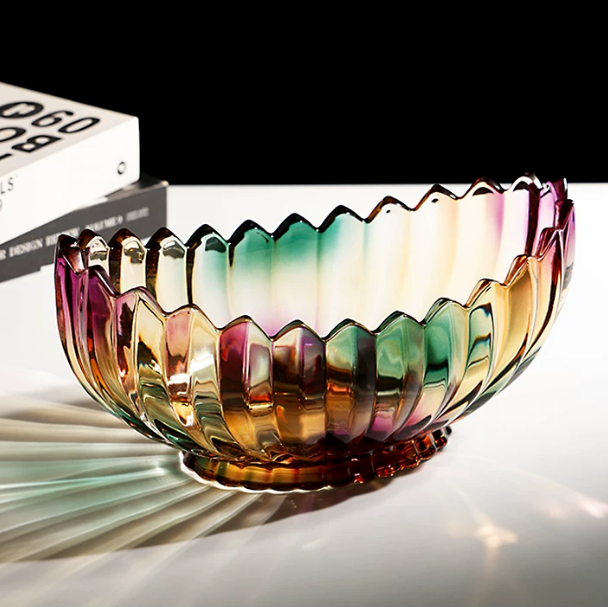 Footed oval iridescent scalloped glass bowl with multicolor finish styled on a dark tabletop