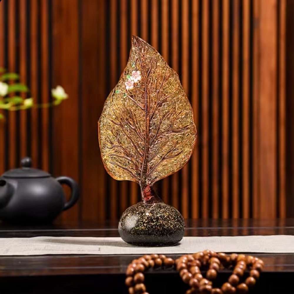 Amber glass leaf sculpture styled on table in warm interior setting