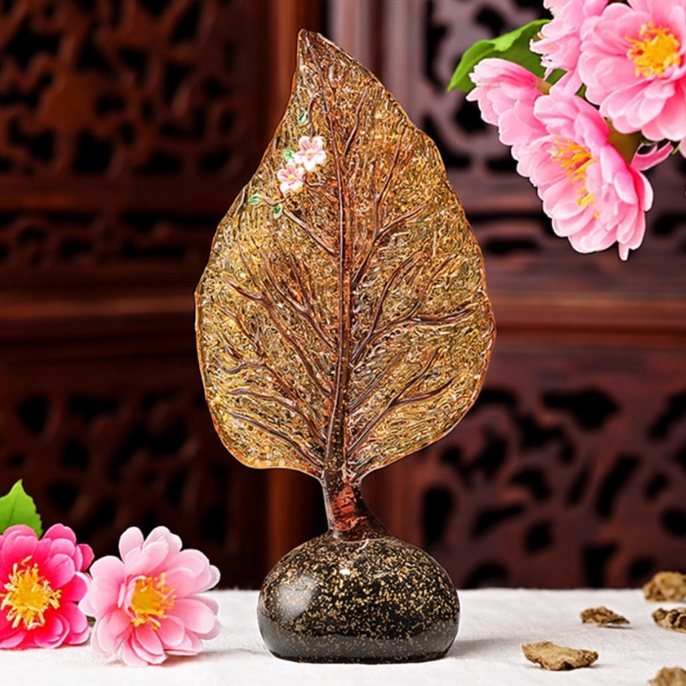 Luxury amber glass leaf sculpture displayed on table with books and decor accents