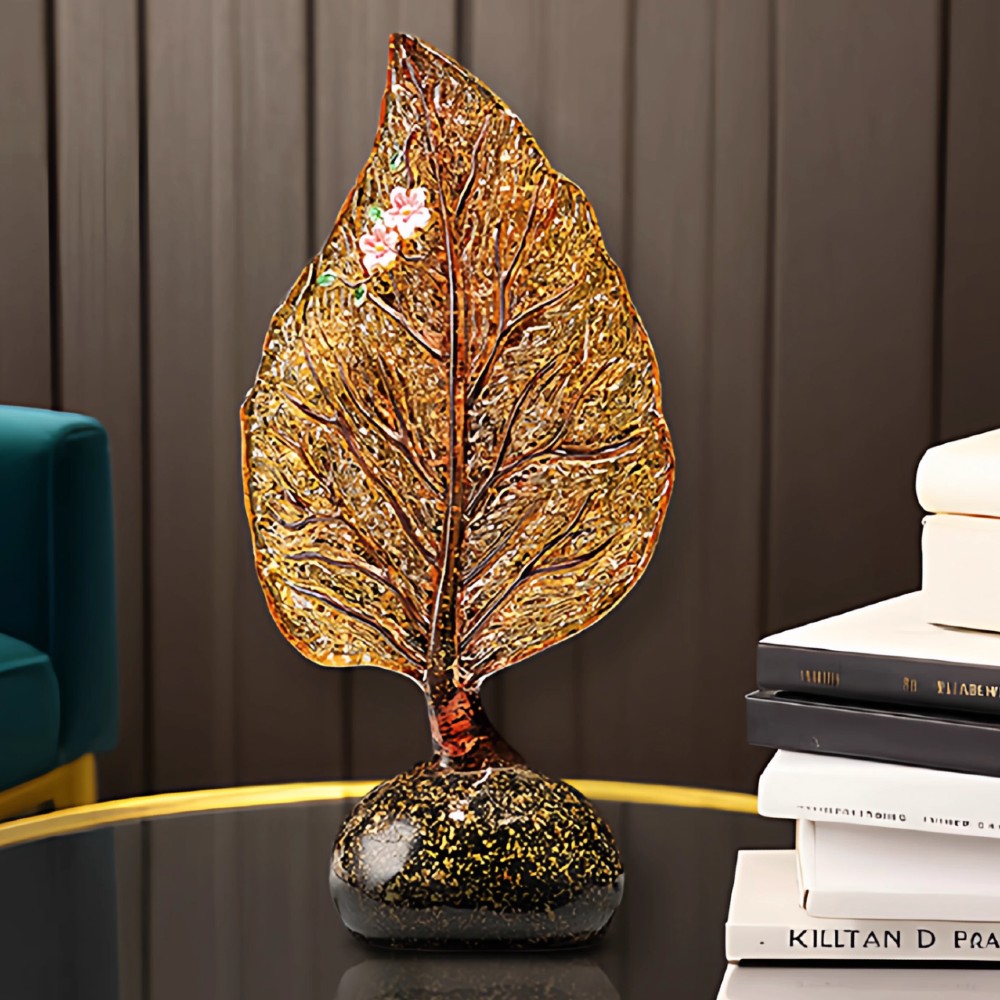Amber glass leaf sculpture placed on side table in modern interior space