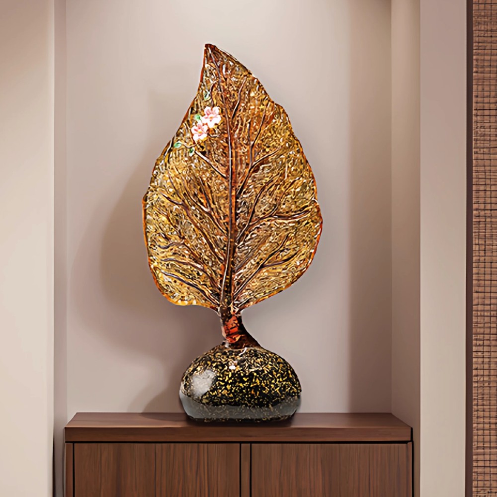 Amber glass leaf sculpture placed on side table in modern interior space