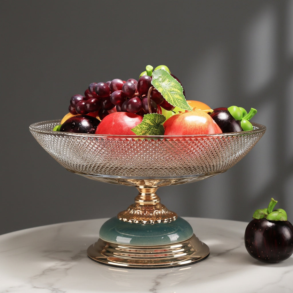 Luxury glass pedestal centerpiece bowl filled with fruit on a marble table