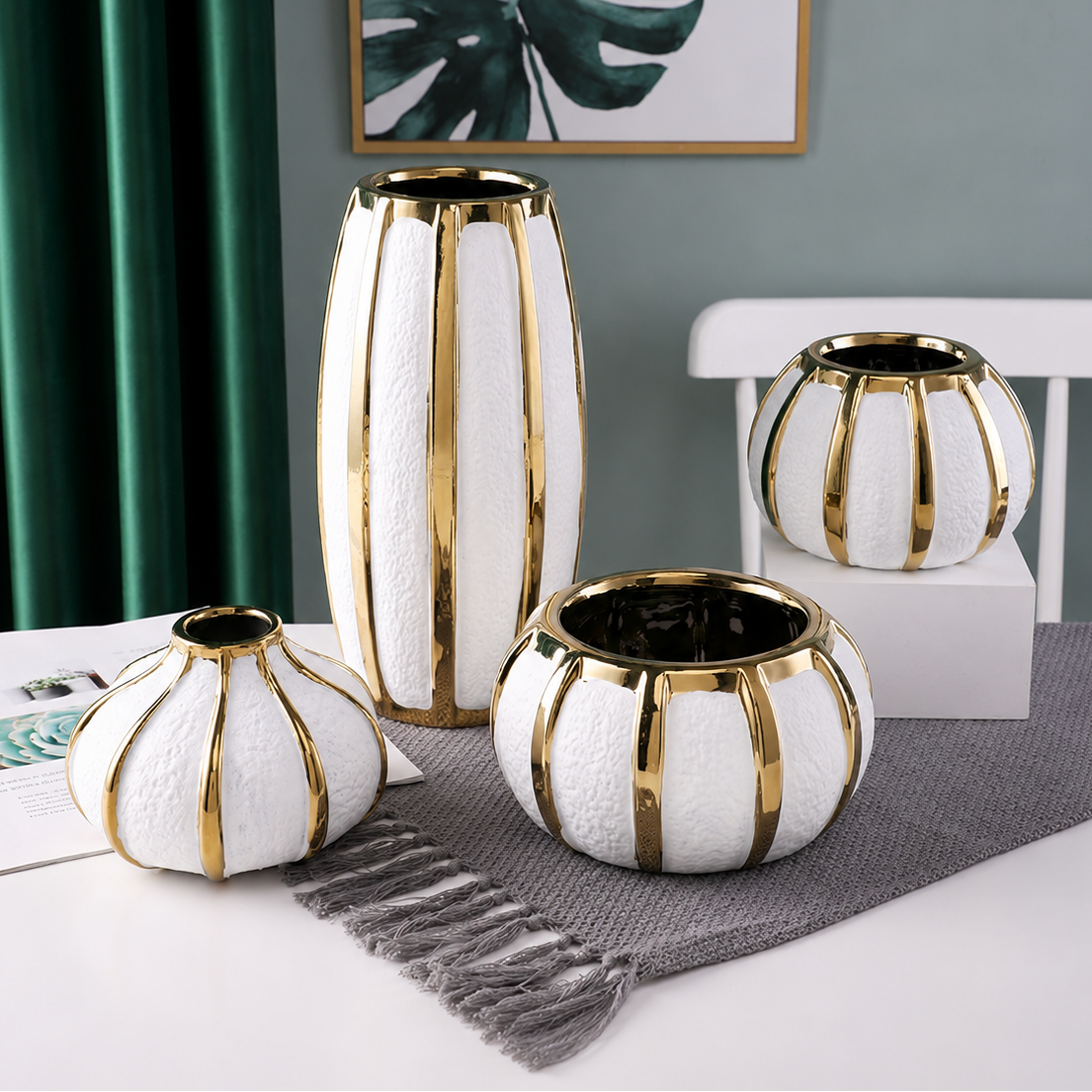 Luxury white ceramic vases with gold accents arranged together in tall, round, and bowl silhouettes