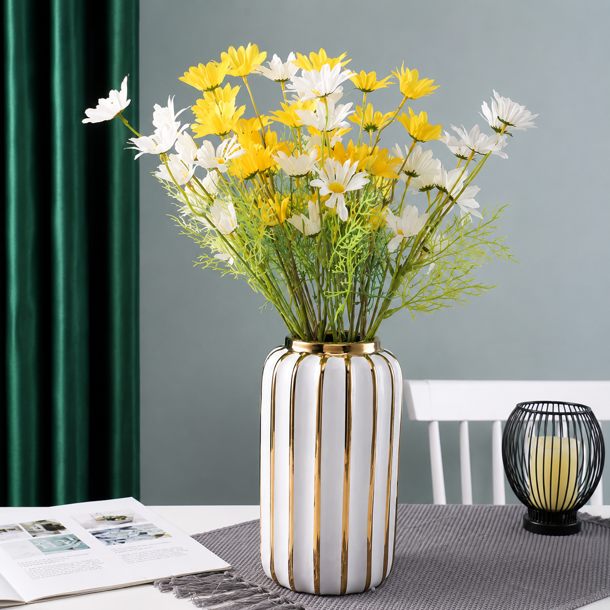 Tall white ceramic vase with gold accents filled with yellow and white flowers