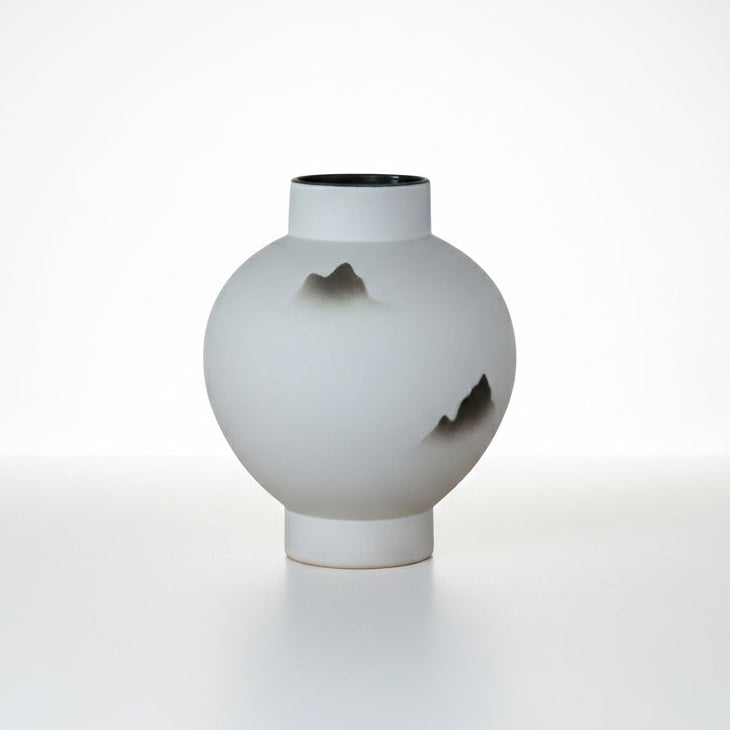 Medium white ceramic round mountain vase on a clean white background