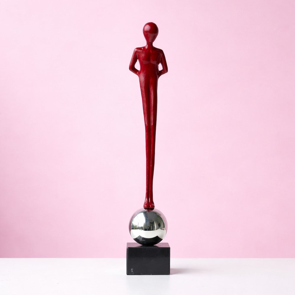 Burgundy standing abstract alloy sculpture with chrome sphere base on black pedestal