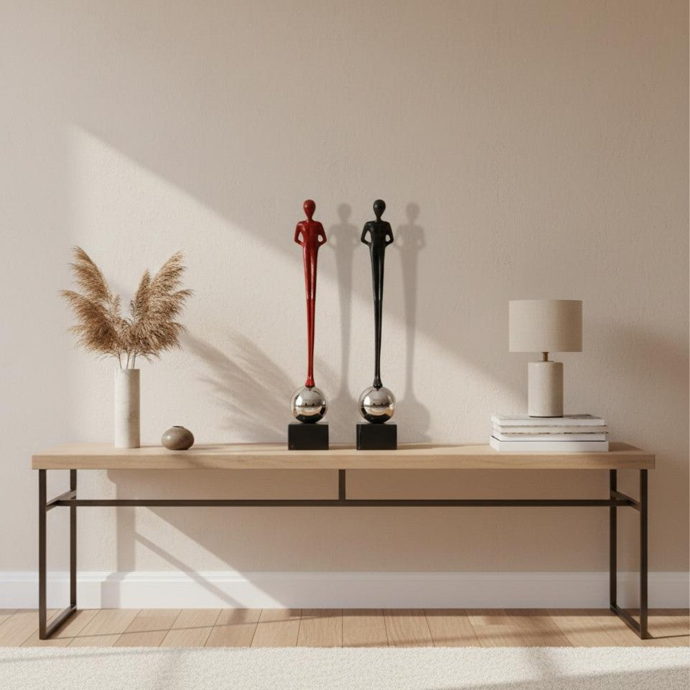 Black and burgundy abstract figure sculptures styled on a modern console table