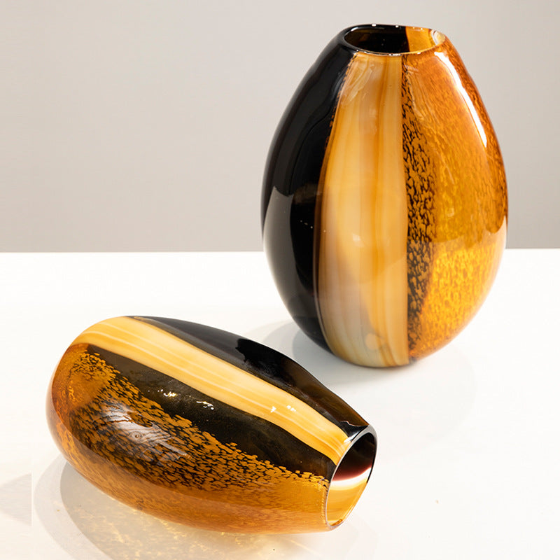 Amber and black hand blown glass vase showing its curved sculptural profile