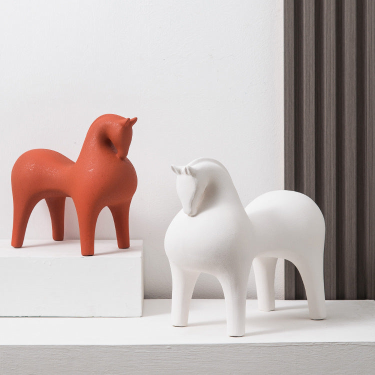 Terracotta red and white ceramic horse sculptures styled together on white pedestals
