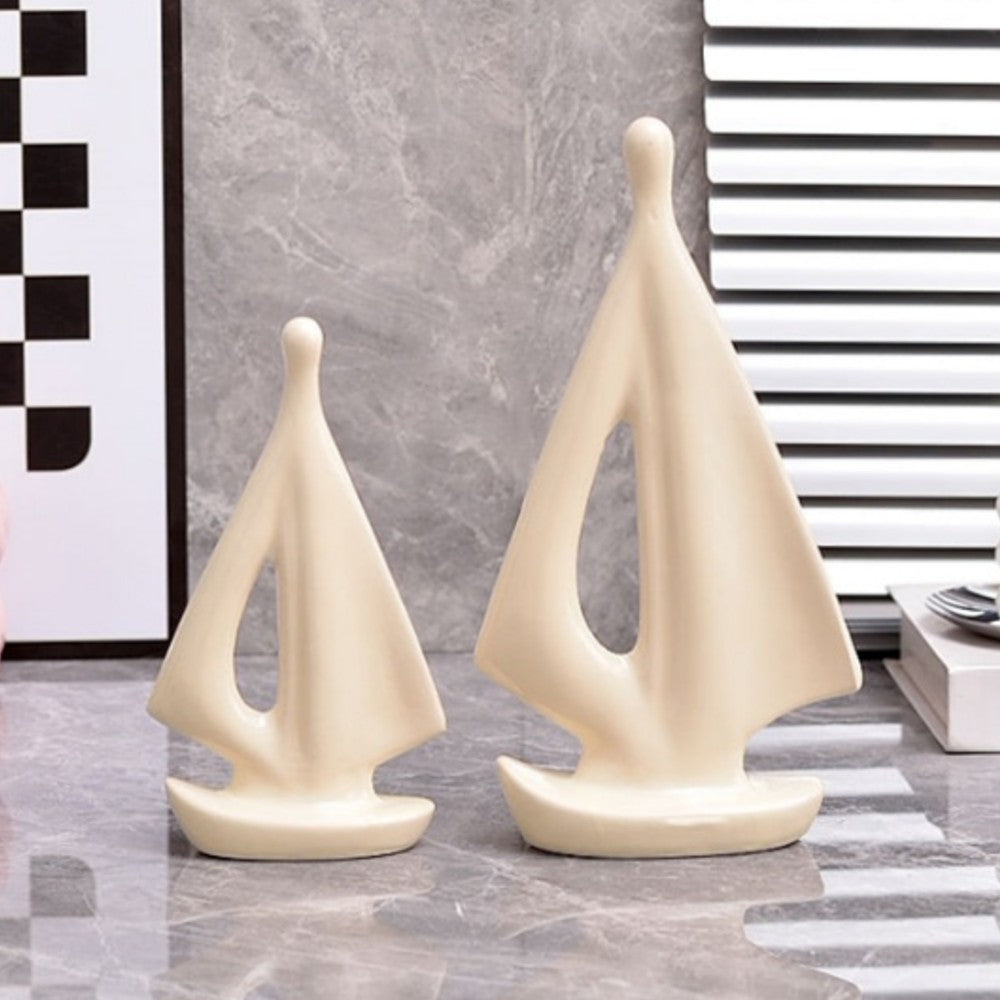 Cream ceramic sailboat sculptures on decorative books for minimalist home decor