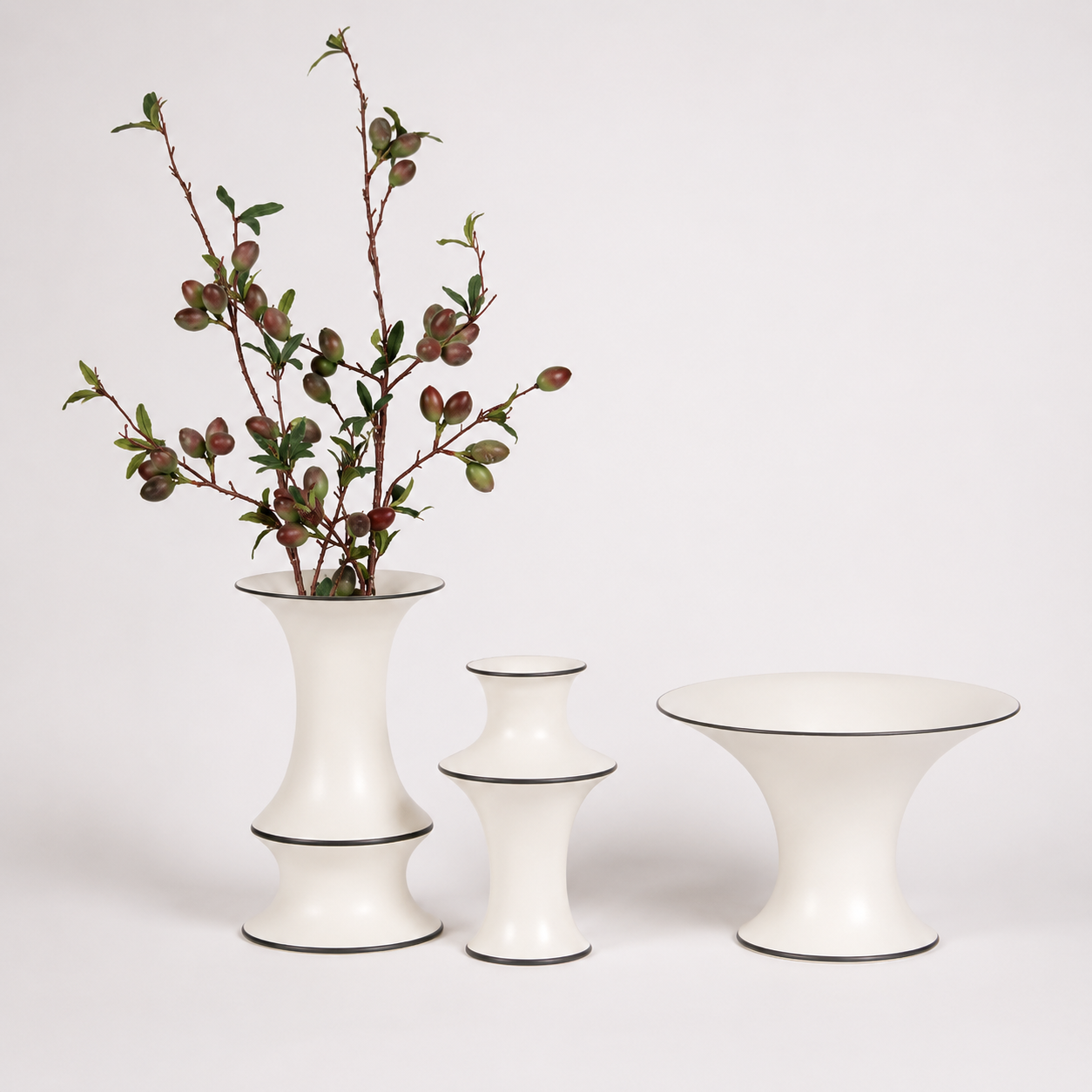 Ivory ceramic vase trio with botanical branches and contrast rim on white background
