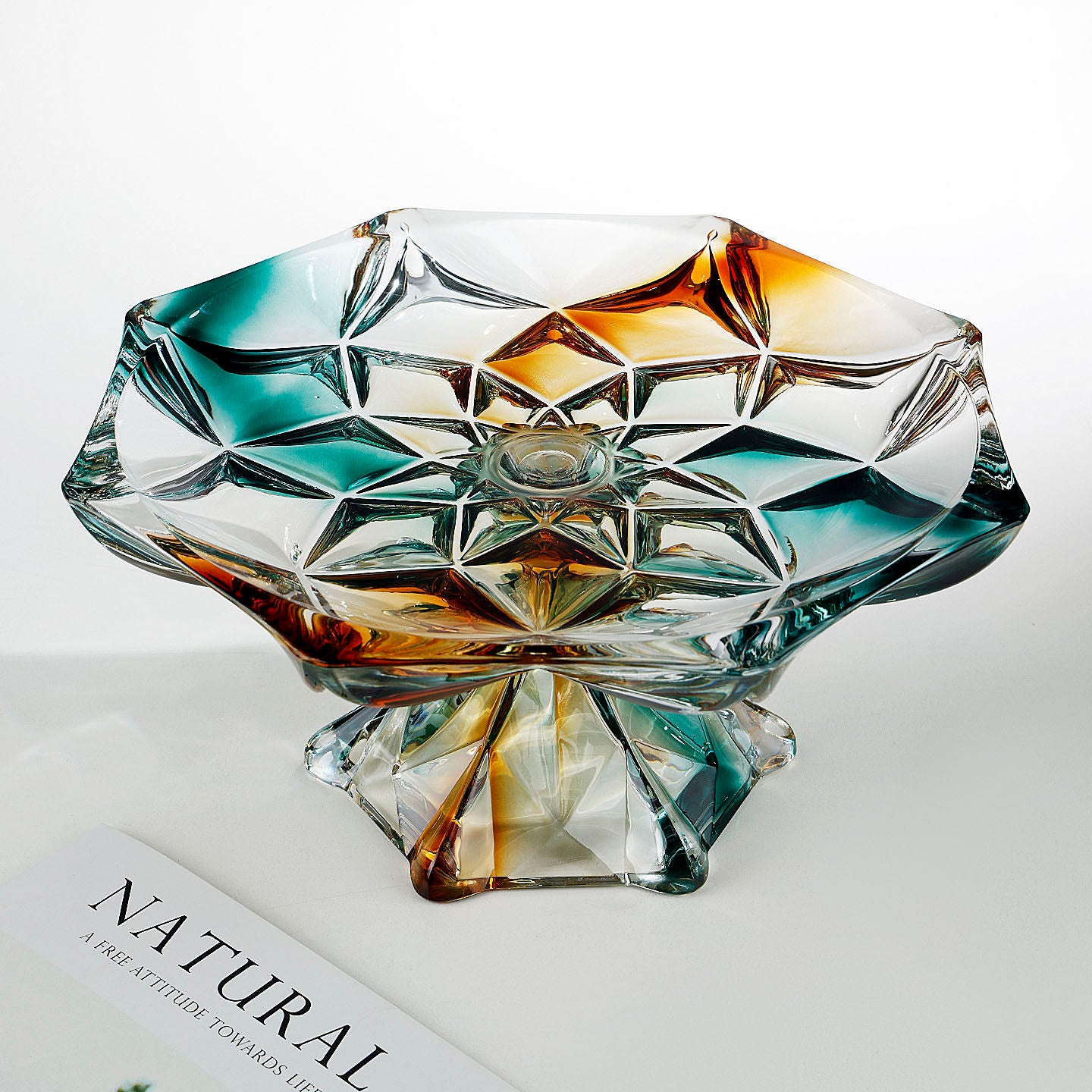 Modern faceted glass pedestal centerpiece bowl shown from an angled front view
