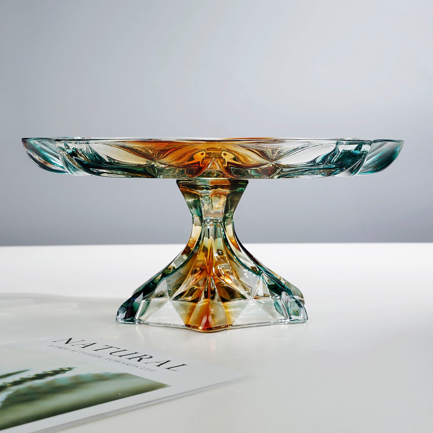 Side profile of geometric teal and amber glass pedestal centerpiece bowl