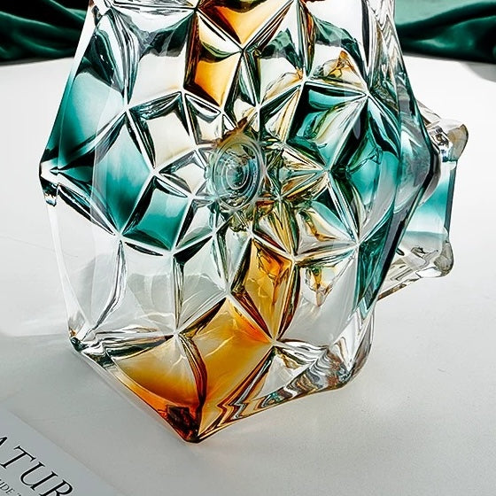 Close up of faceted glass pedestal base showing geometric teal and amber detailing