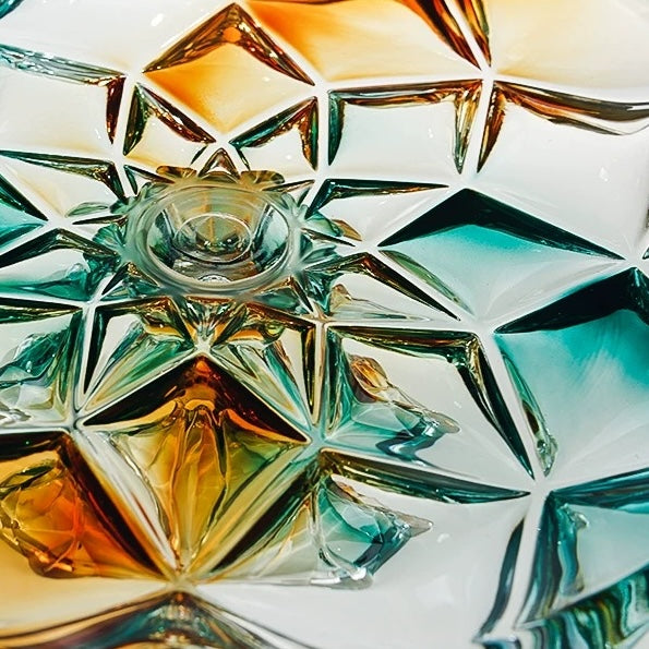 Close up of teal amber and clear geometric glass facets on centerpiece bowl