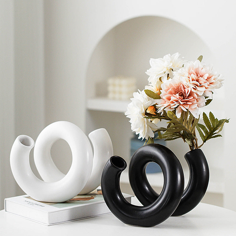 Black and white loop ceramic vases styled with flowers in a modern interior