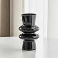 Black modern sculptural glass flower vase on a white table