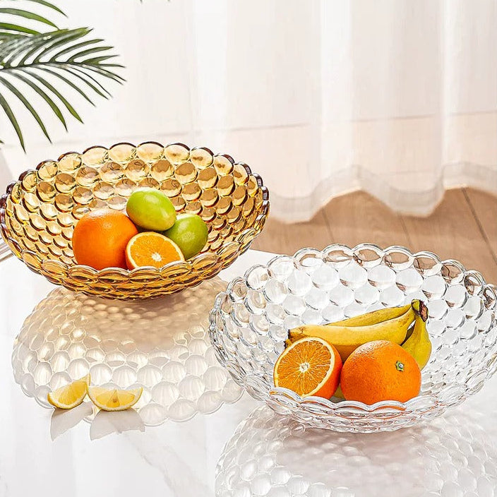 Amber bubble glass bowl with oranges beside a clear textured glass bowl