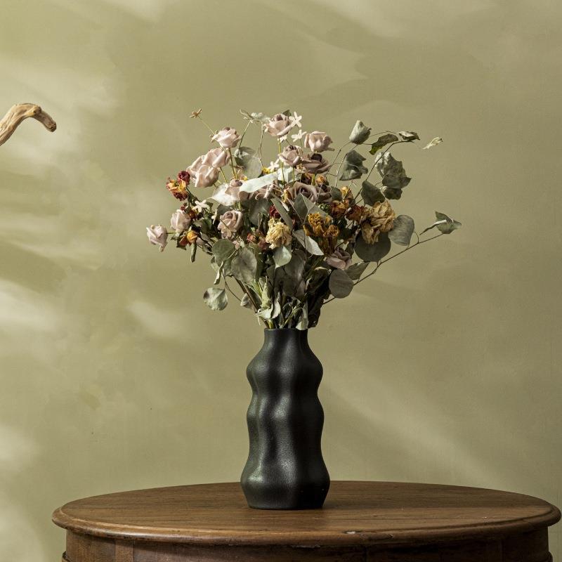 Black wavy ceramic flower vase styled with a dried floral arrangement