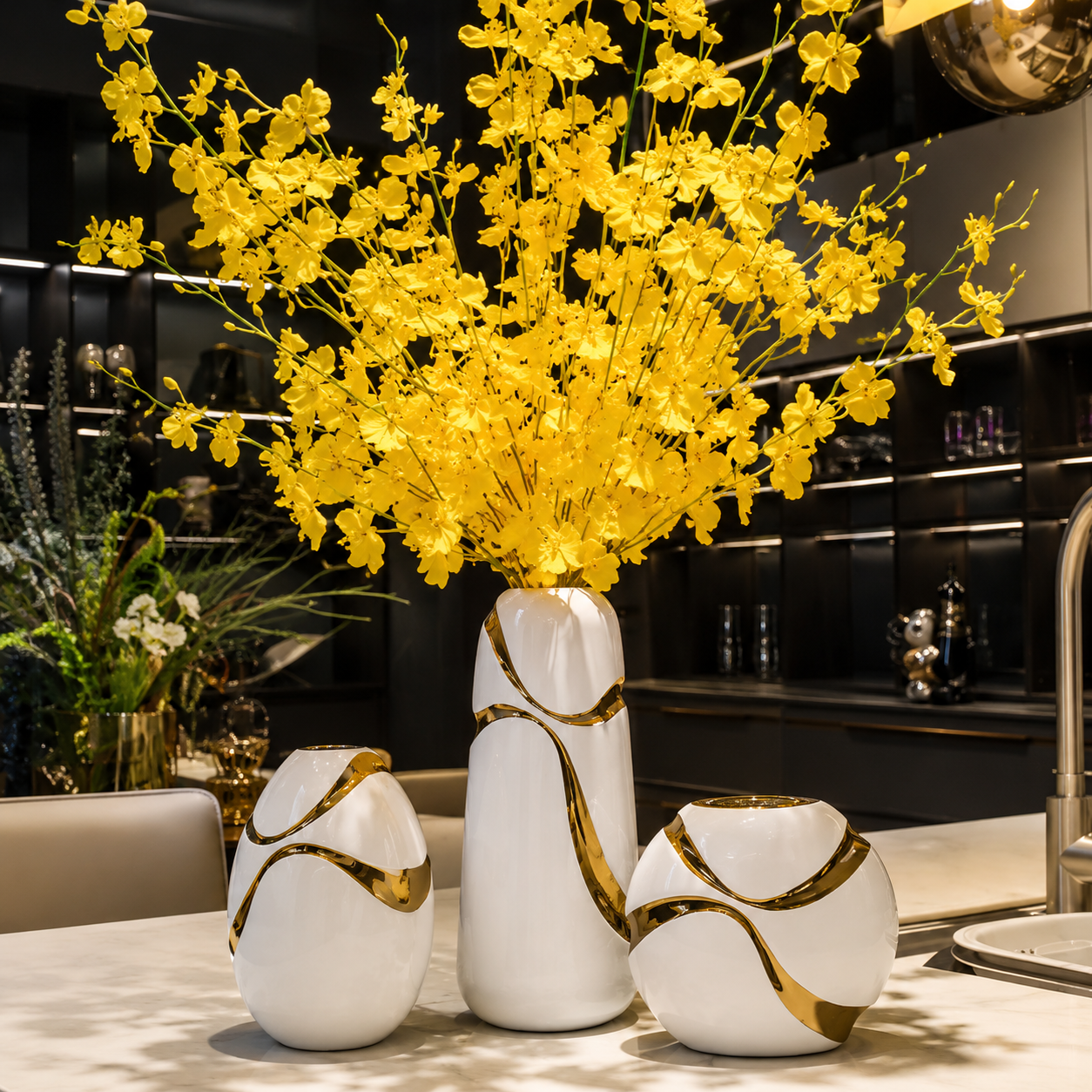 White and gold ceramic vase set styled with bright yellow flowers in a modern interior