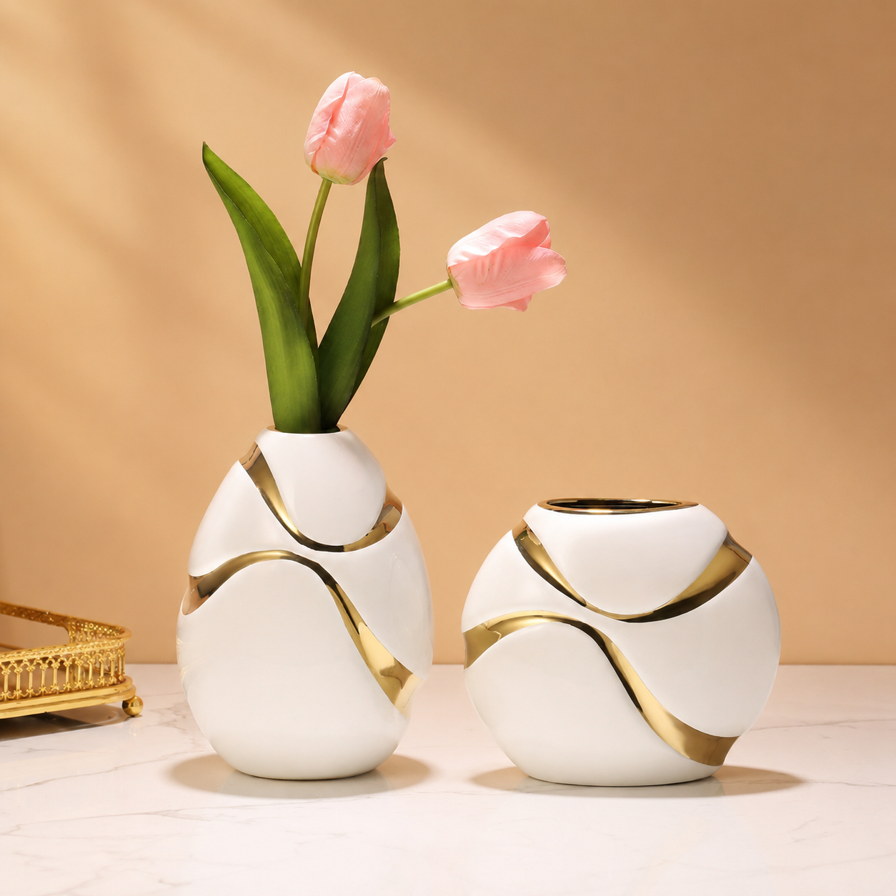 White ceramic vase set with gold ribbon accents styled with pink tulips