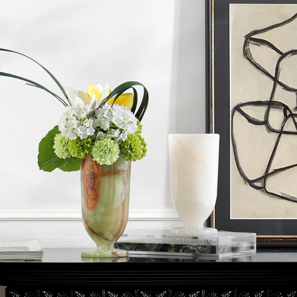 Natural marble pedestal flower vase styled with floral arrangement beside white marble vase on luxury console table